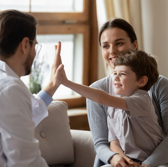 Image showing a smiling doctor give high five to a little boy patient